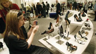 A customer photographs a display of heels as Saks Fifth Avenue unveils 17 August 2007 "10022-SHOE", the new designer shoe floor that's so big it has its own zip code. The grand opening of 10022-SHOE, Saks Fifth Avenue?s vastly expanded designer shoe floor in the New York flagship store will hold a place in marketing history as the first floor to brand its location as a literal shopping destination. AFP PHOTO/ TIMOTHY A. CLARY (Photo credit should read TIMOTHY A. CLARY/AFP via Getty Images)