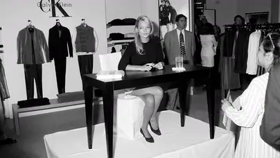 Kate Moss (seated) appears at a Saks Fifth Avenue store in Los Angeles, California, on September 19, 1995.