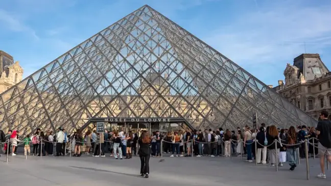 Tourists at the entrance to the pyramid leading into the Louvre Museum in Paris, France, on October 2, 2026. An illustration of tourism at Paris’s major museums. (Photo by Antoine Boureau / Hans Lucas via AFP)