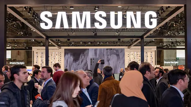 People walk in front of a Samsung booth.
