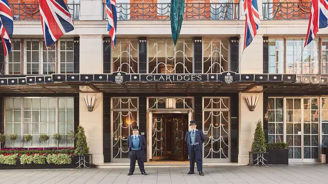 Front exterior of Claridge's hotel with doormen standing at attention, London